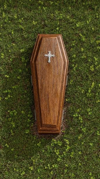 Plain polished hardwood coffin with a metal cross on the lid, from the Heaven Funeral Services coffin shop in Wayanad