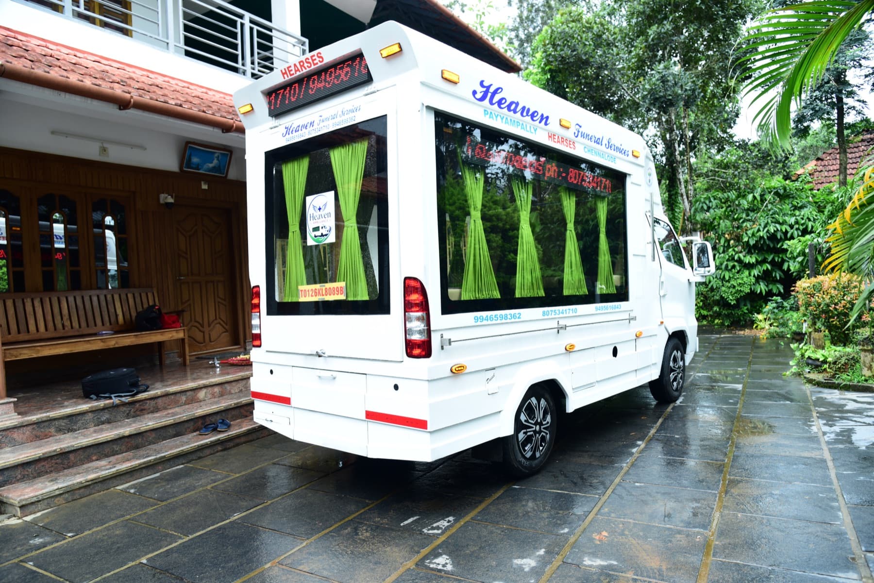 Rear and side view of the enclosed Heaven Funeral Services transport vehicle