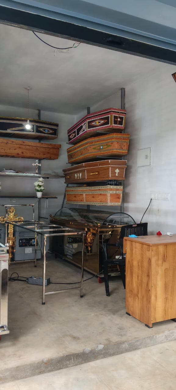 Racks of handcrafted wooden and decorated coffins inside the showroom