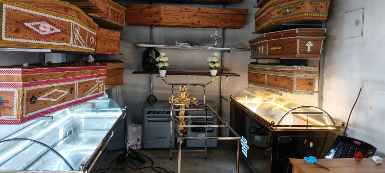 Wide interior view of the Heaven Funeral Services showroom with coffin racks and display freezers